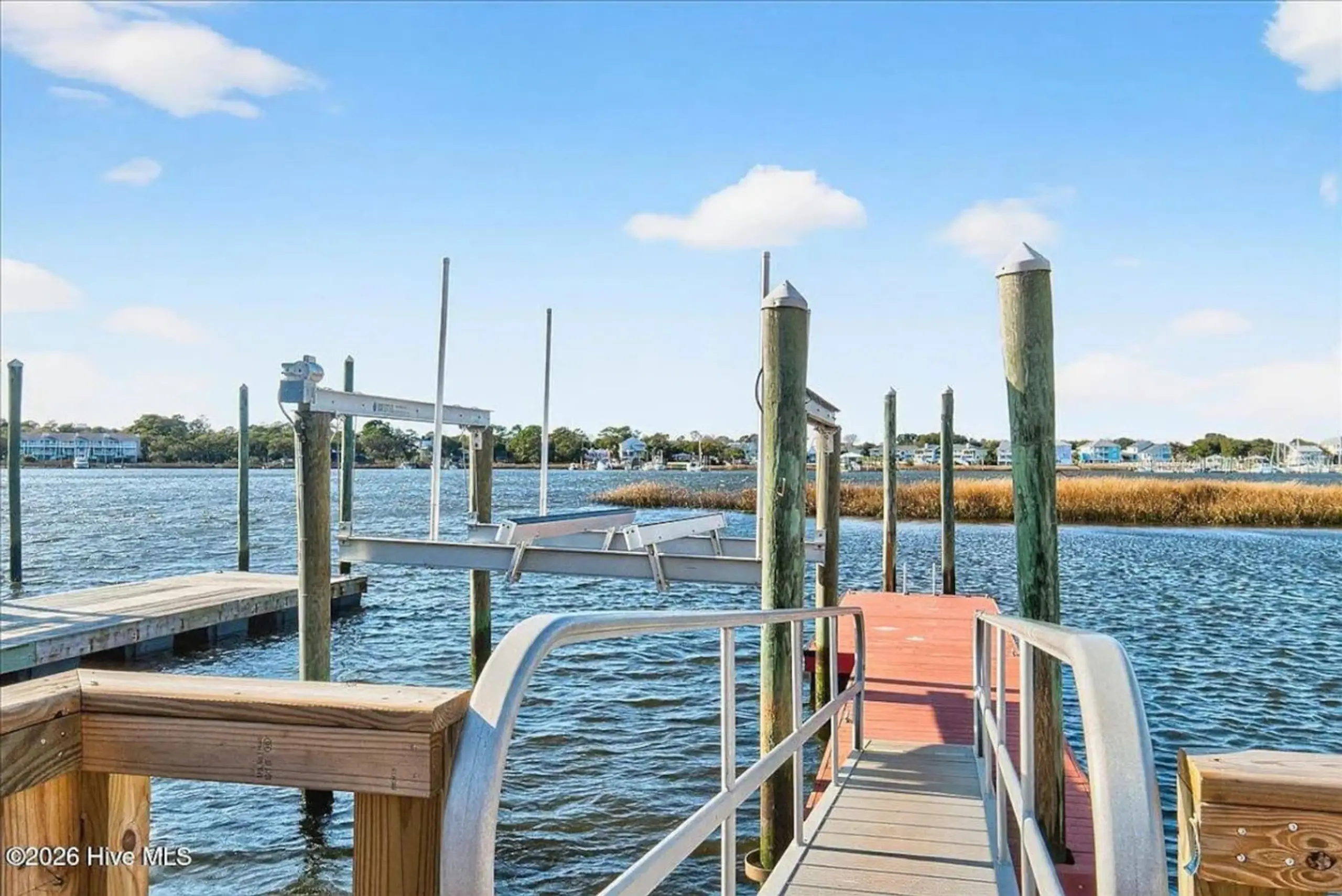 Wooden dock with boat lifts on bay