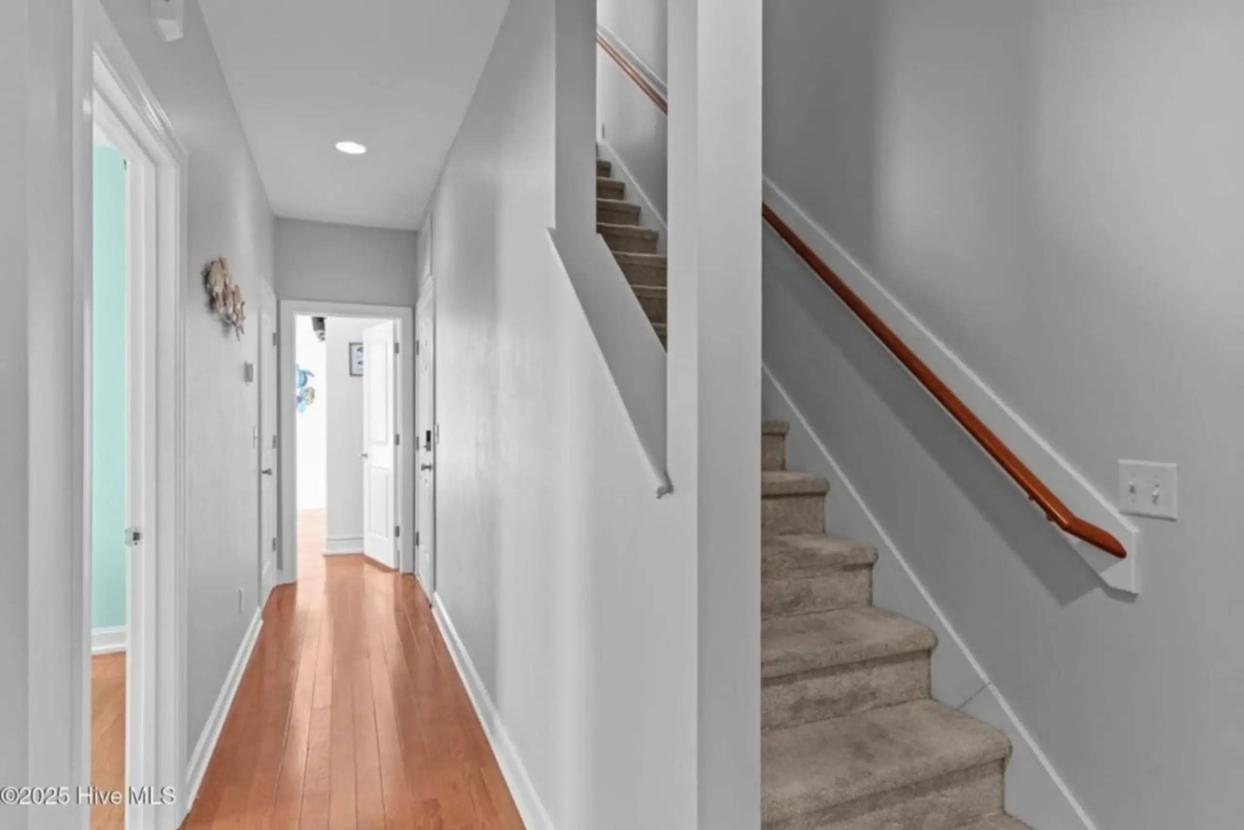 Interior hallway with hardwood floor and stairs