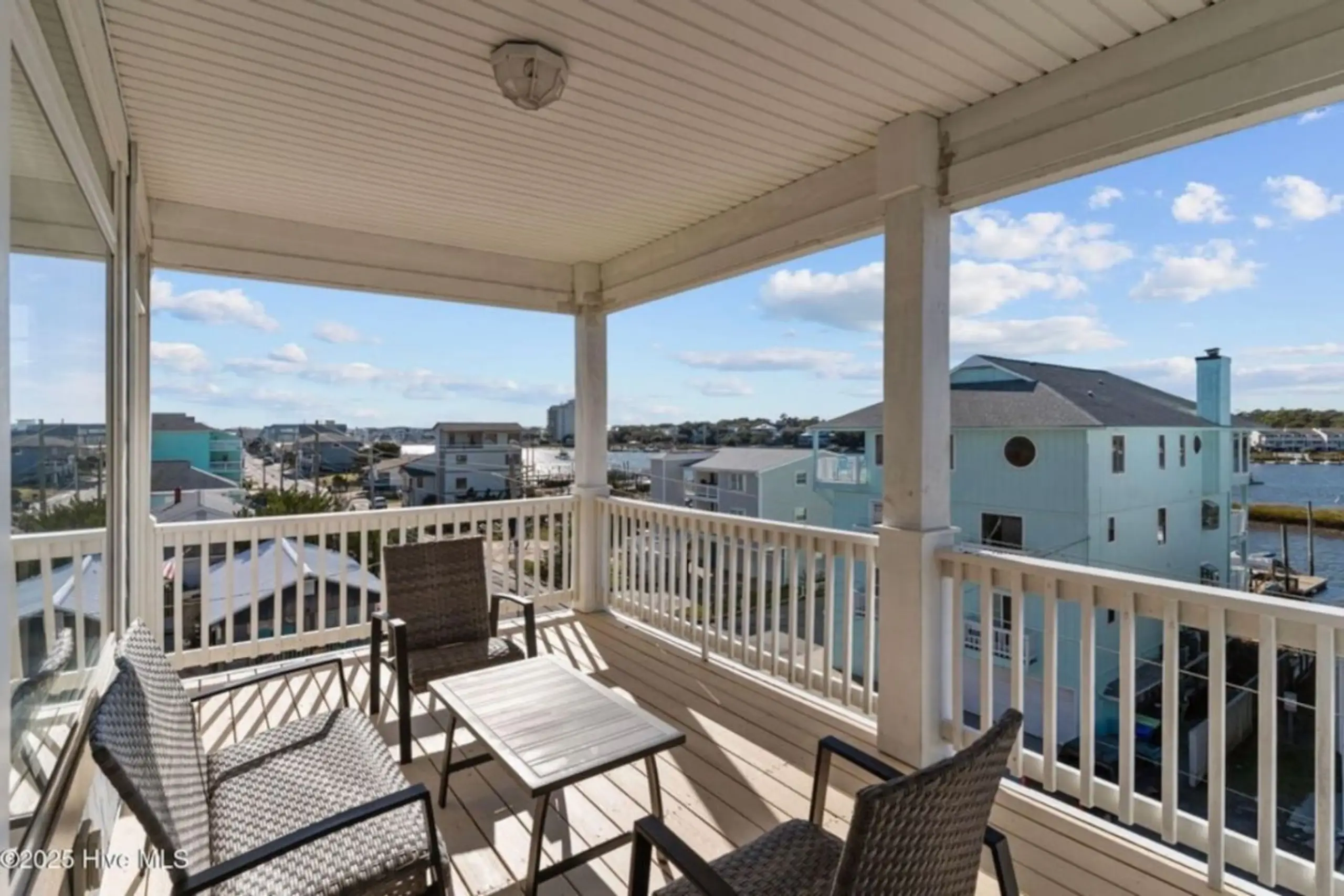 Covered balcony with patio furniture and water view