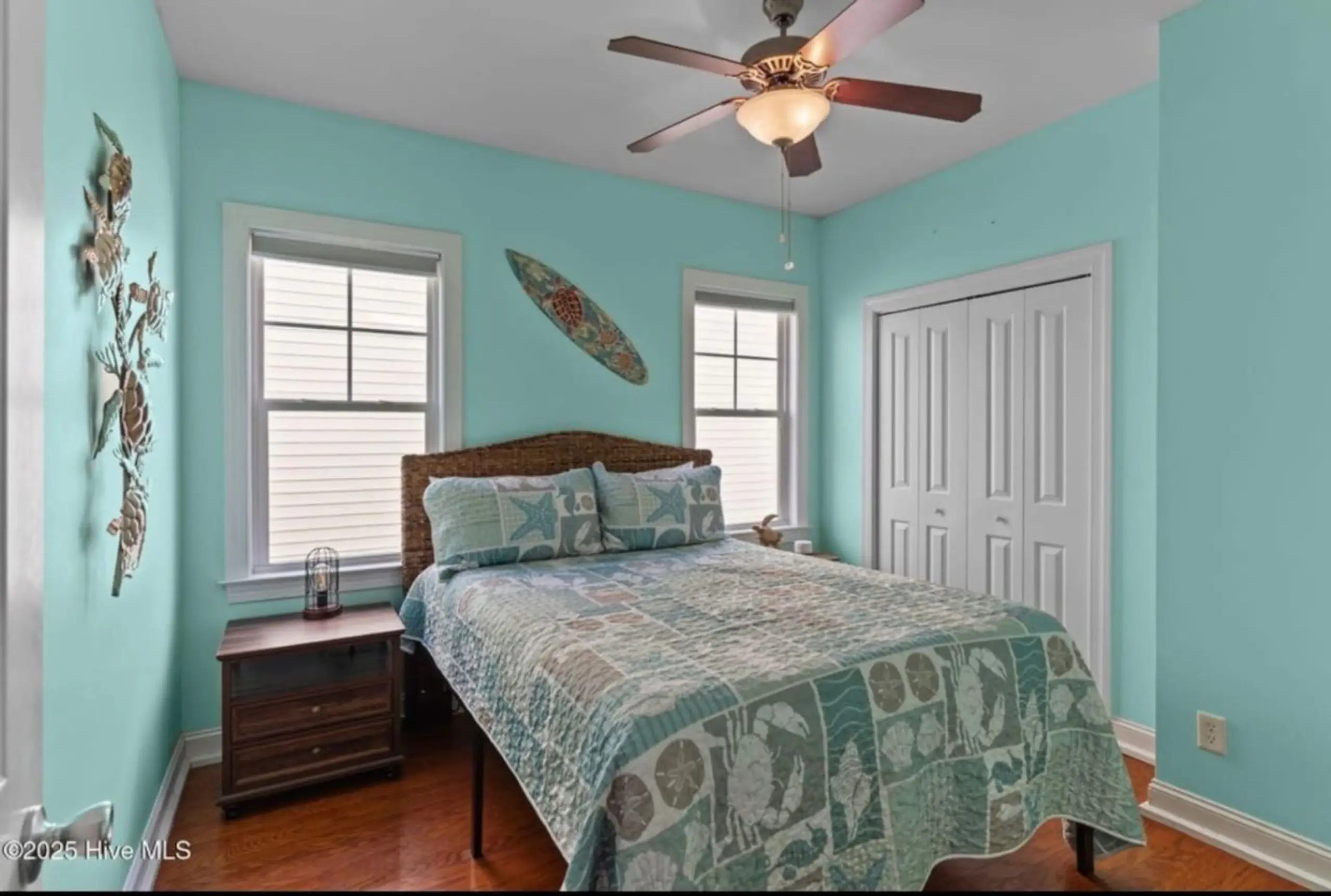 Coastal bedroom with teal walls and patterned bedding