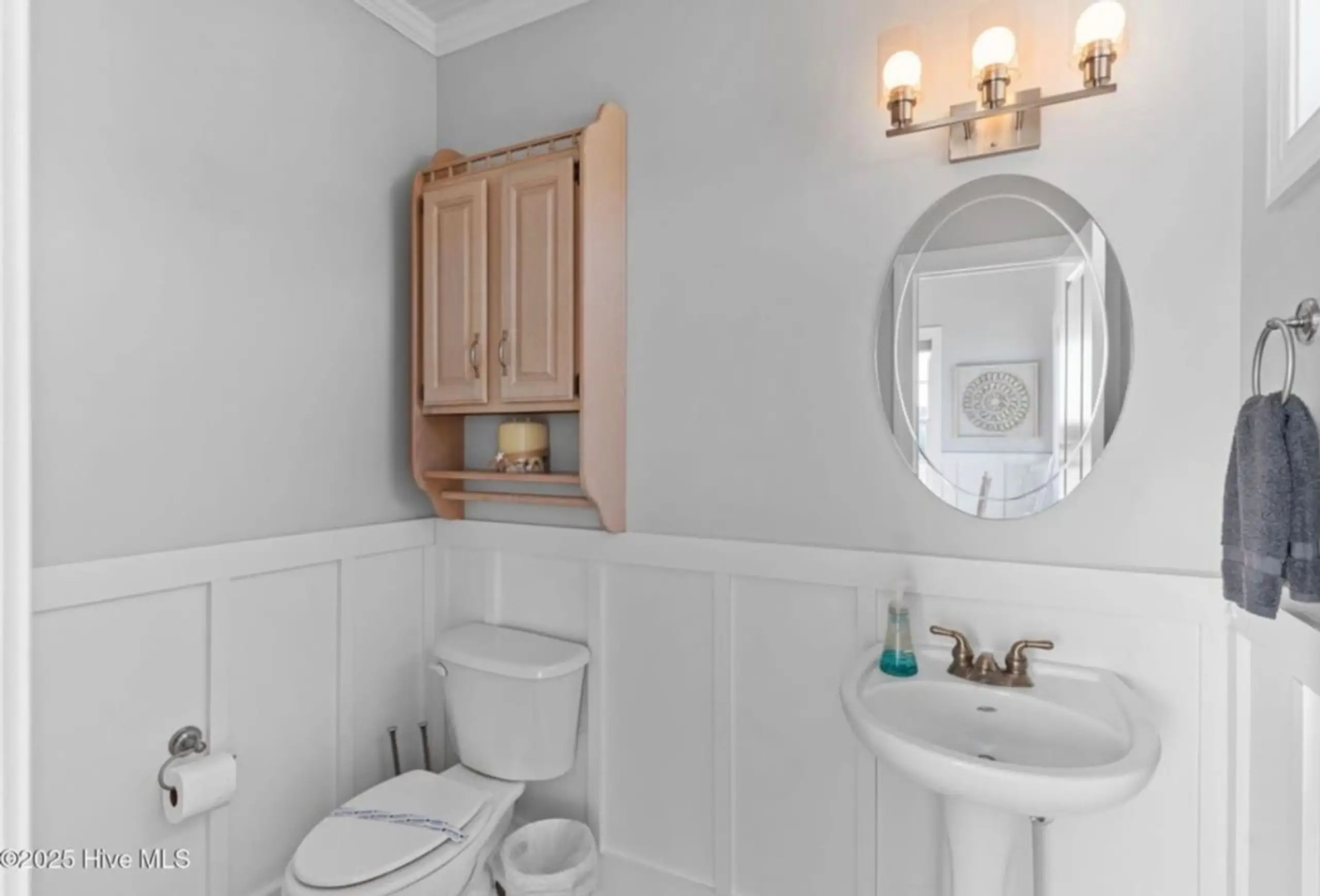 Bright powder room with pedestal sink and toilet