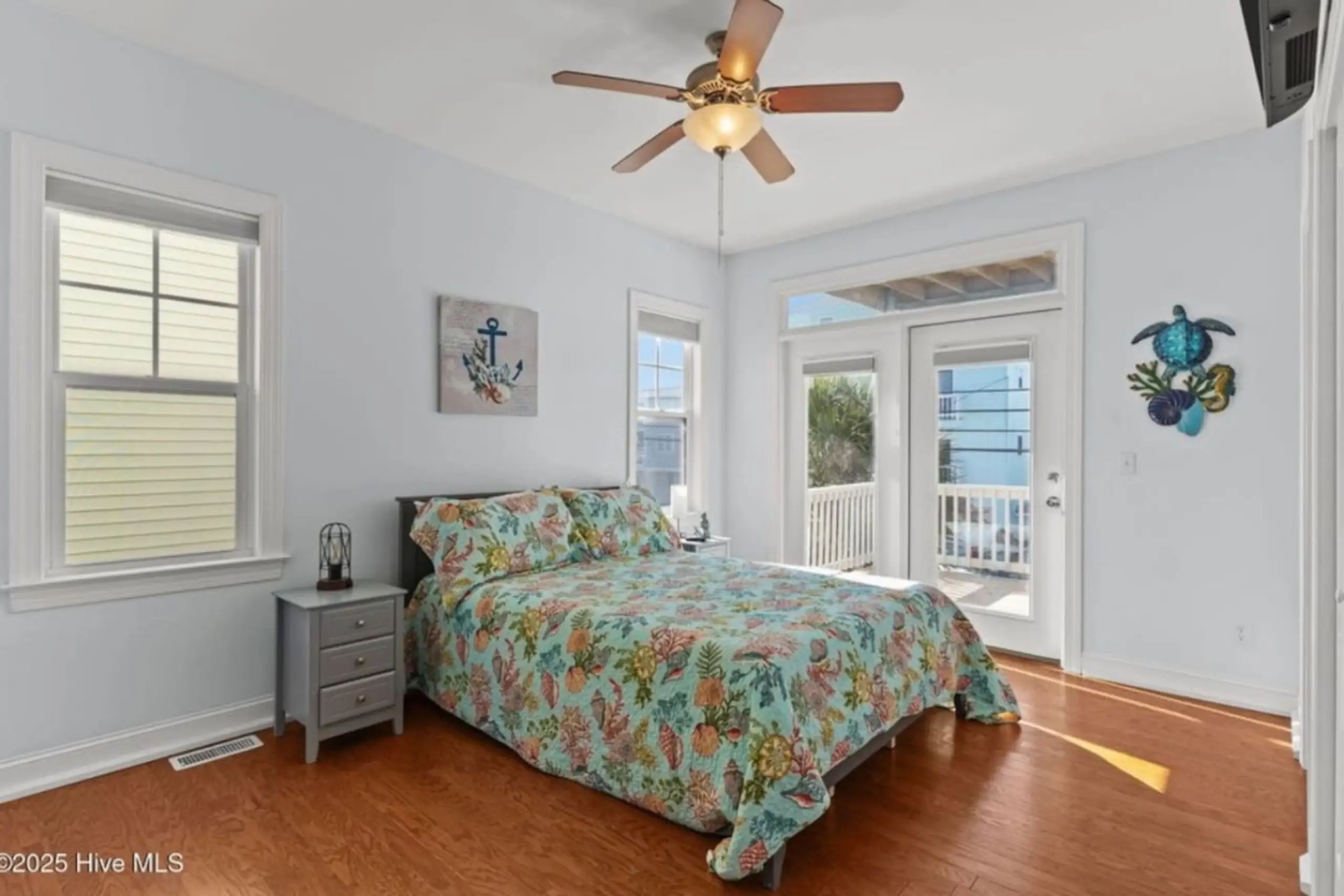 Coastal bedroom with floral bedding and balcony