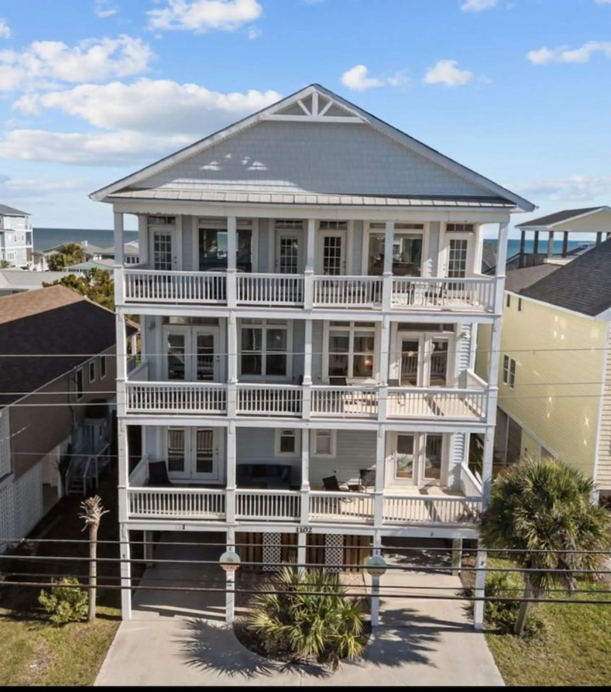 Four-story white beach house with balconies