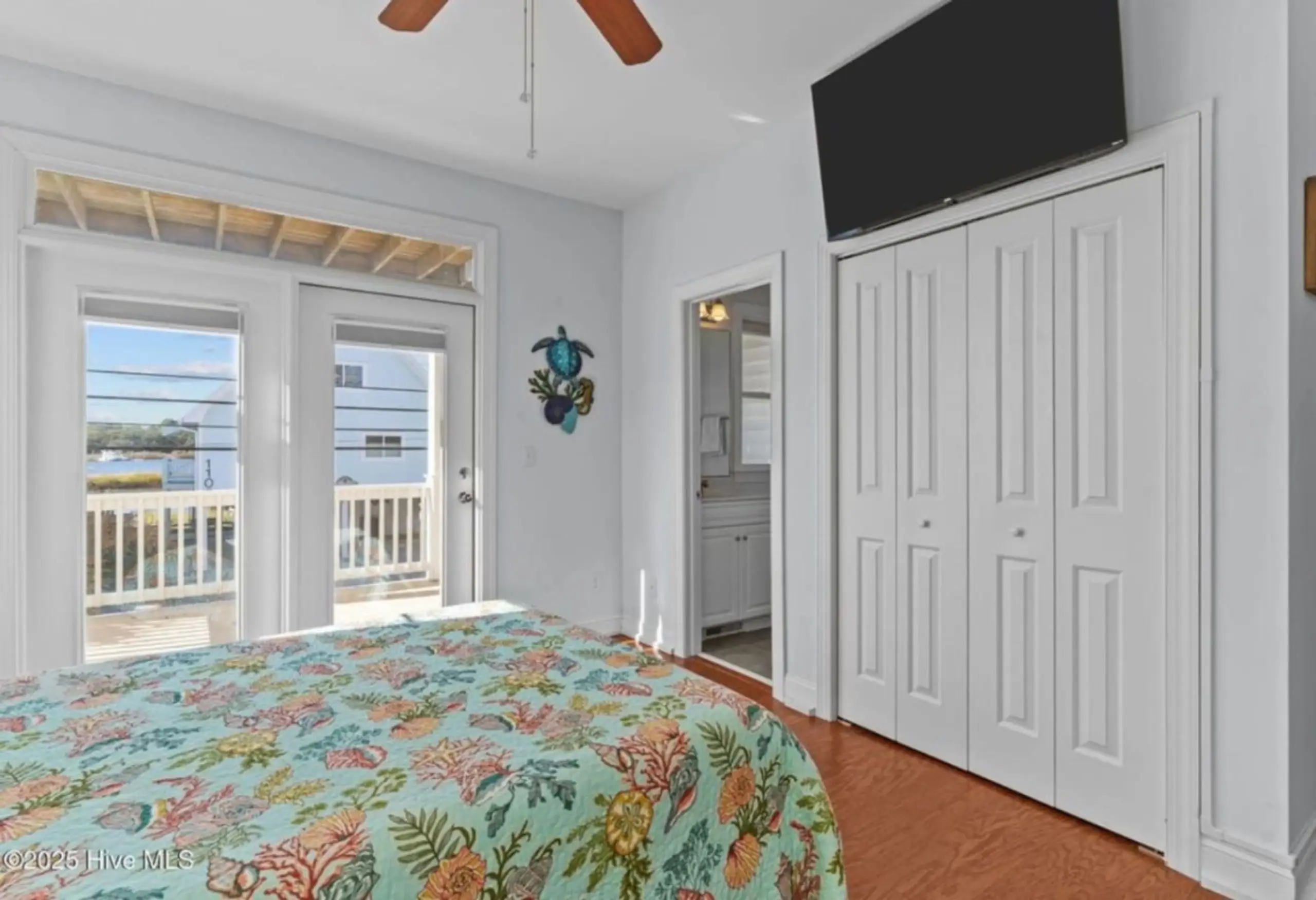 Coastal bedroom with floral bed and water view