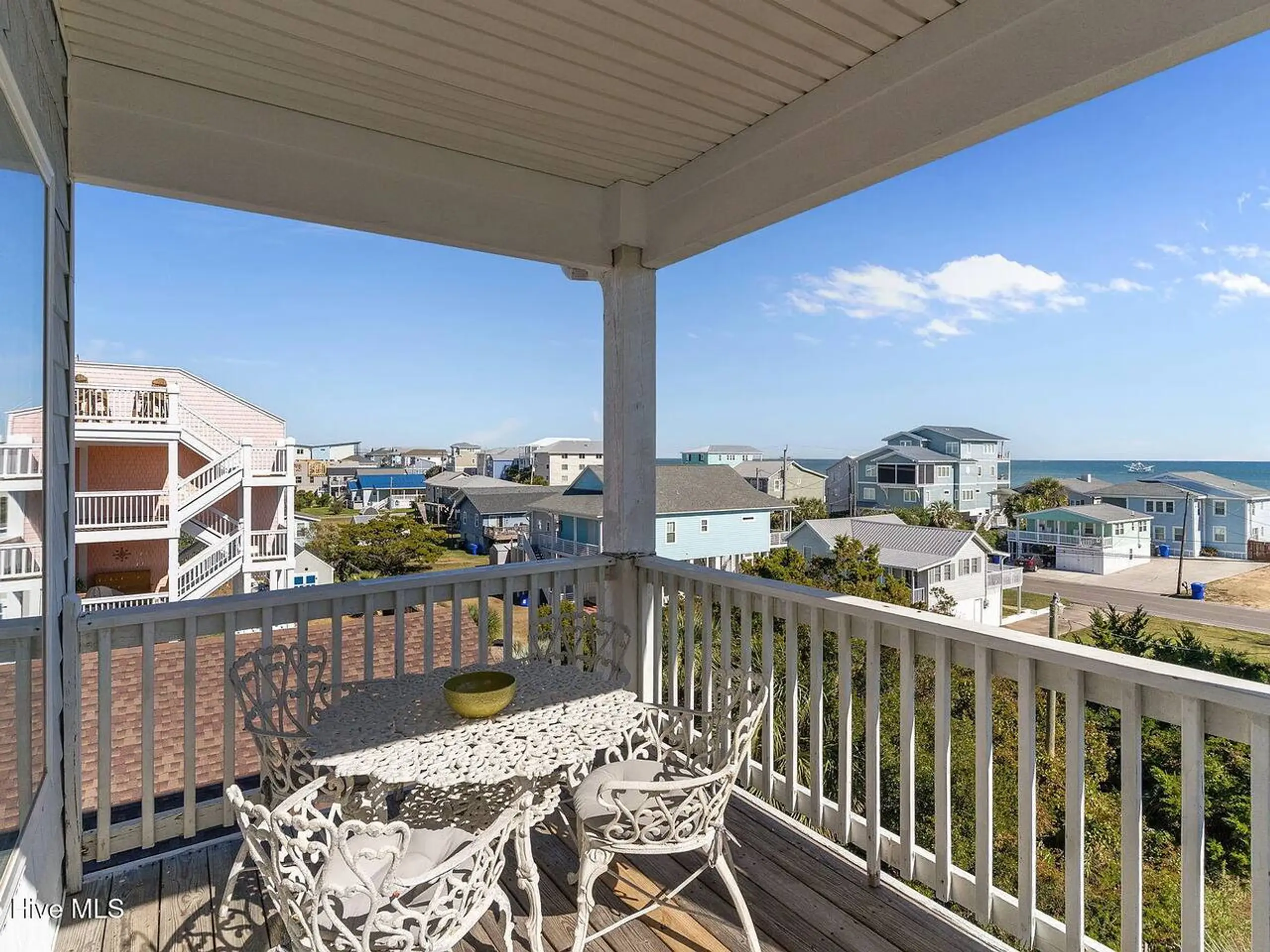 Covered balcony overlooking beach houses and ocean