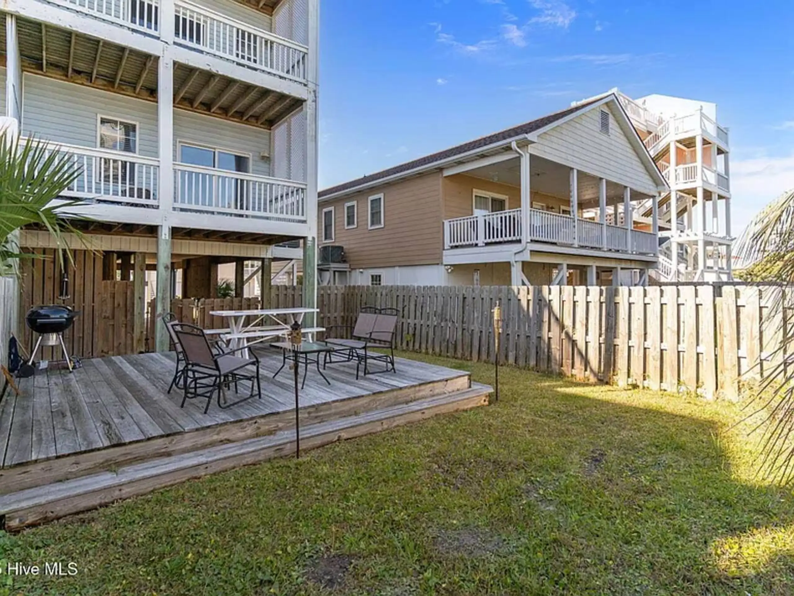 Fenced backyard with wooden deck and grill