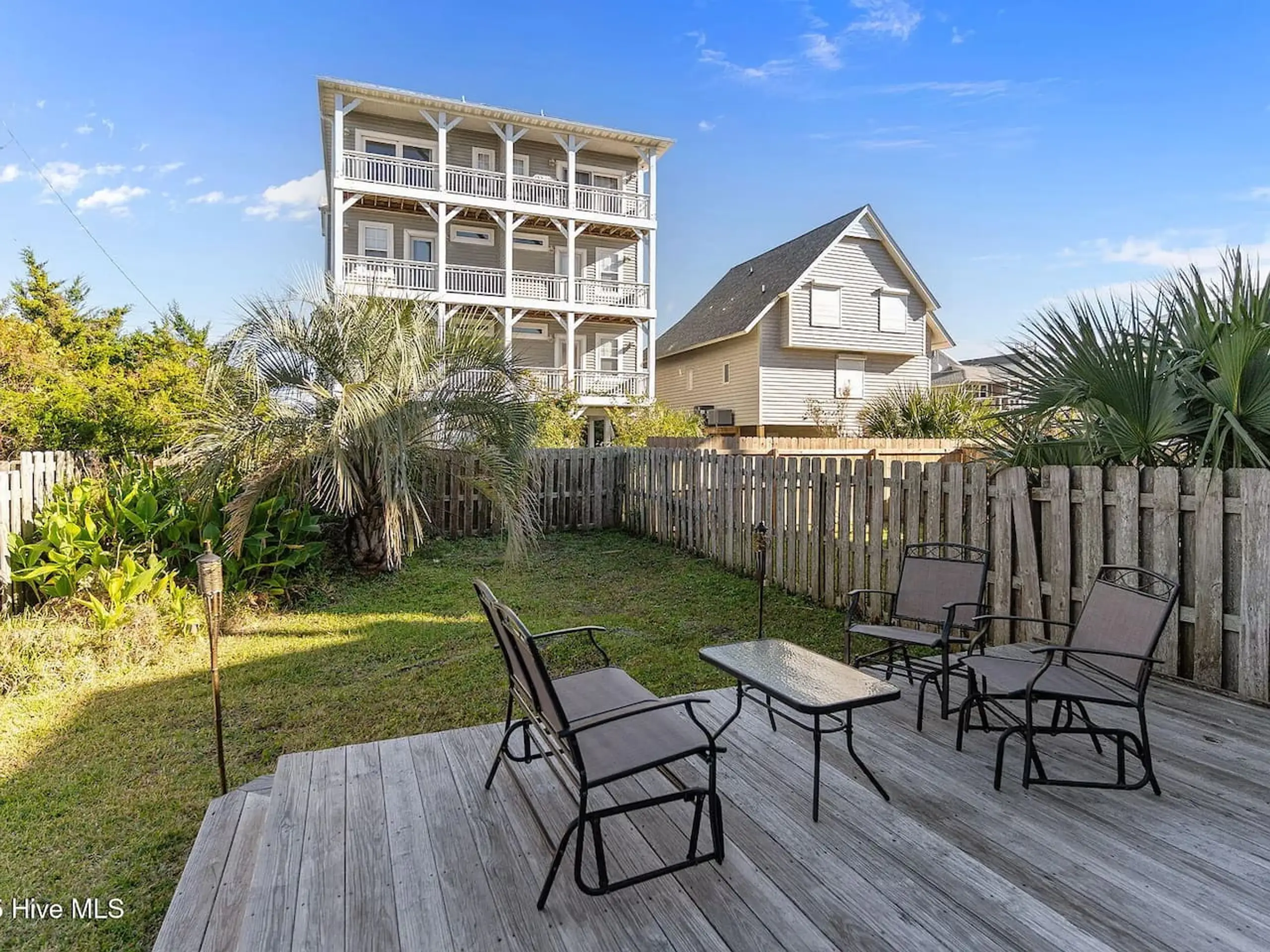 Backyard deck with patio chairs and beach house