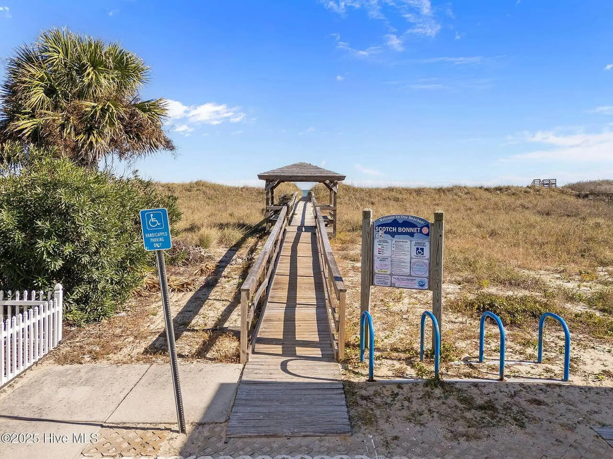 Wooden boardwalk leading to sandy beach dunes