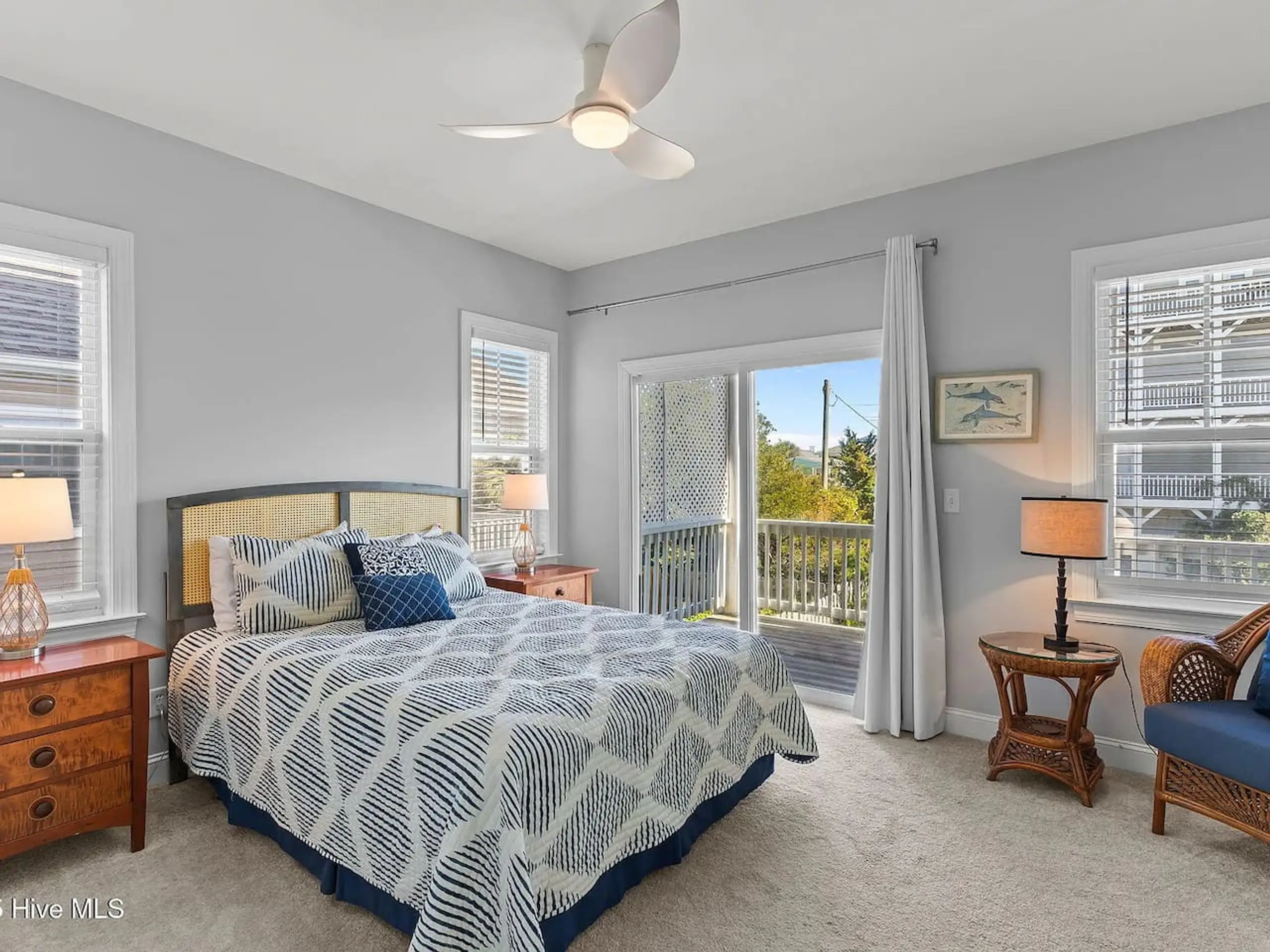 Sunlit coastal bedroom with patterned blue quilt