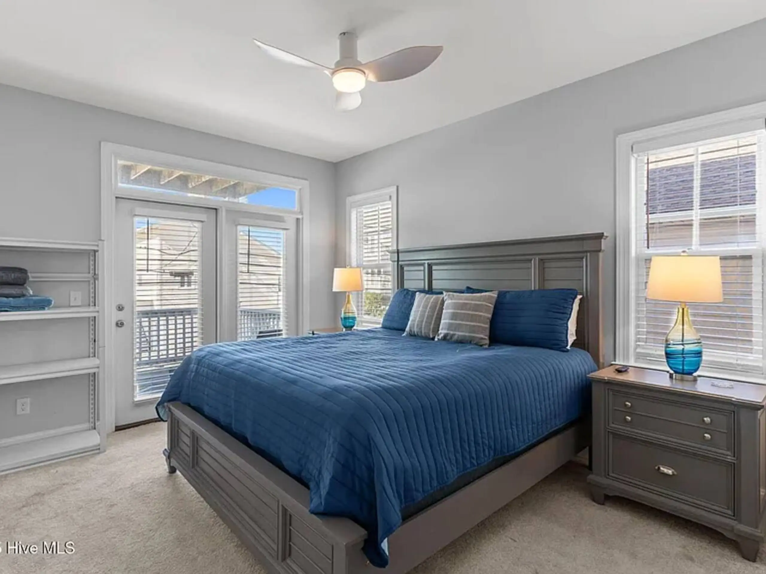 Contemporary bedroom with navy bedding and balcony