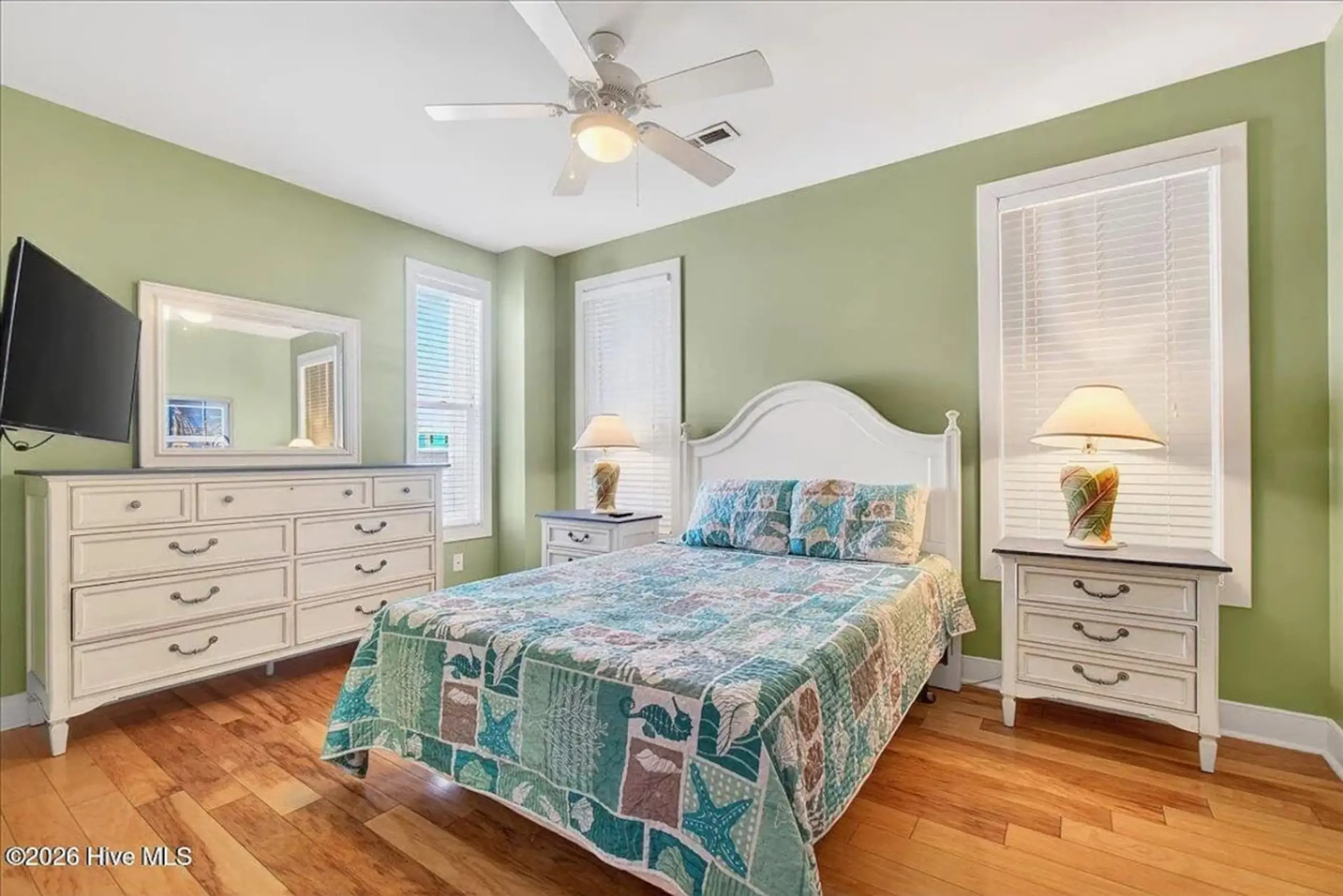 Coastal bedroom with white furniture and quilt