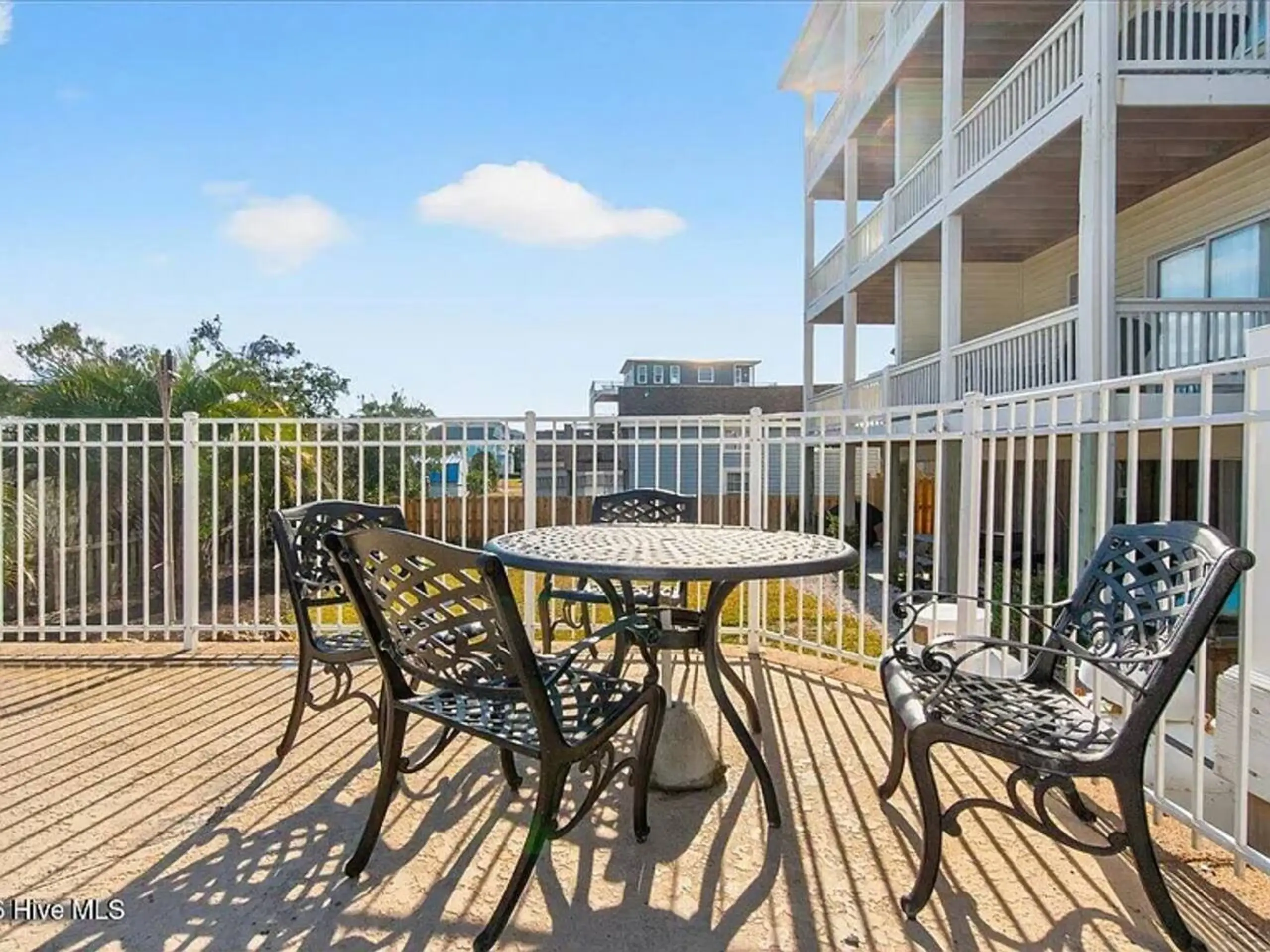 Sunlit balcony with metal table and chairs