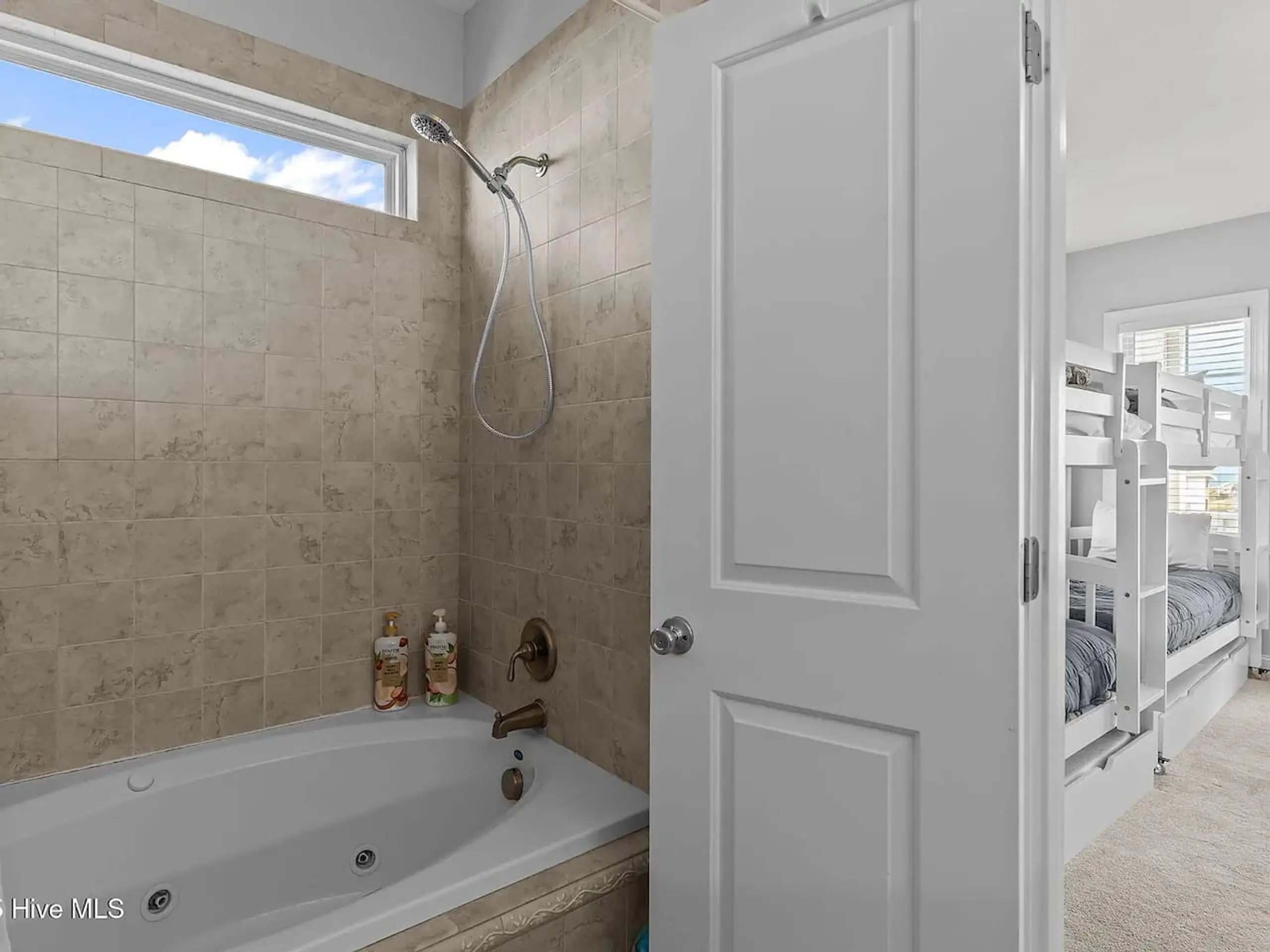 Bathroom with tub and bunk bed view