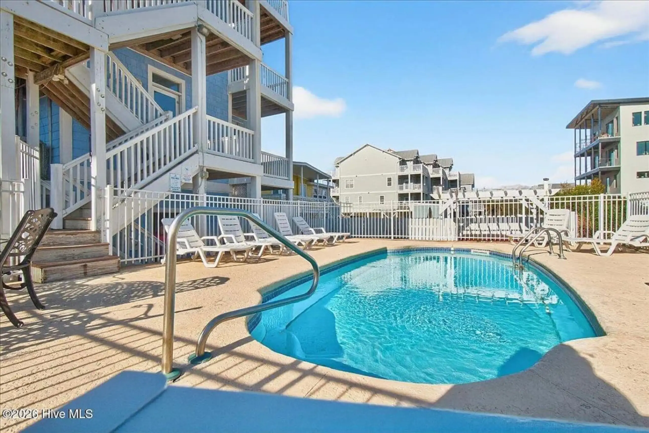 Outdoor pool with loungers at beachfront condos