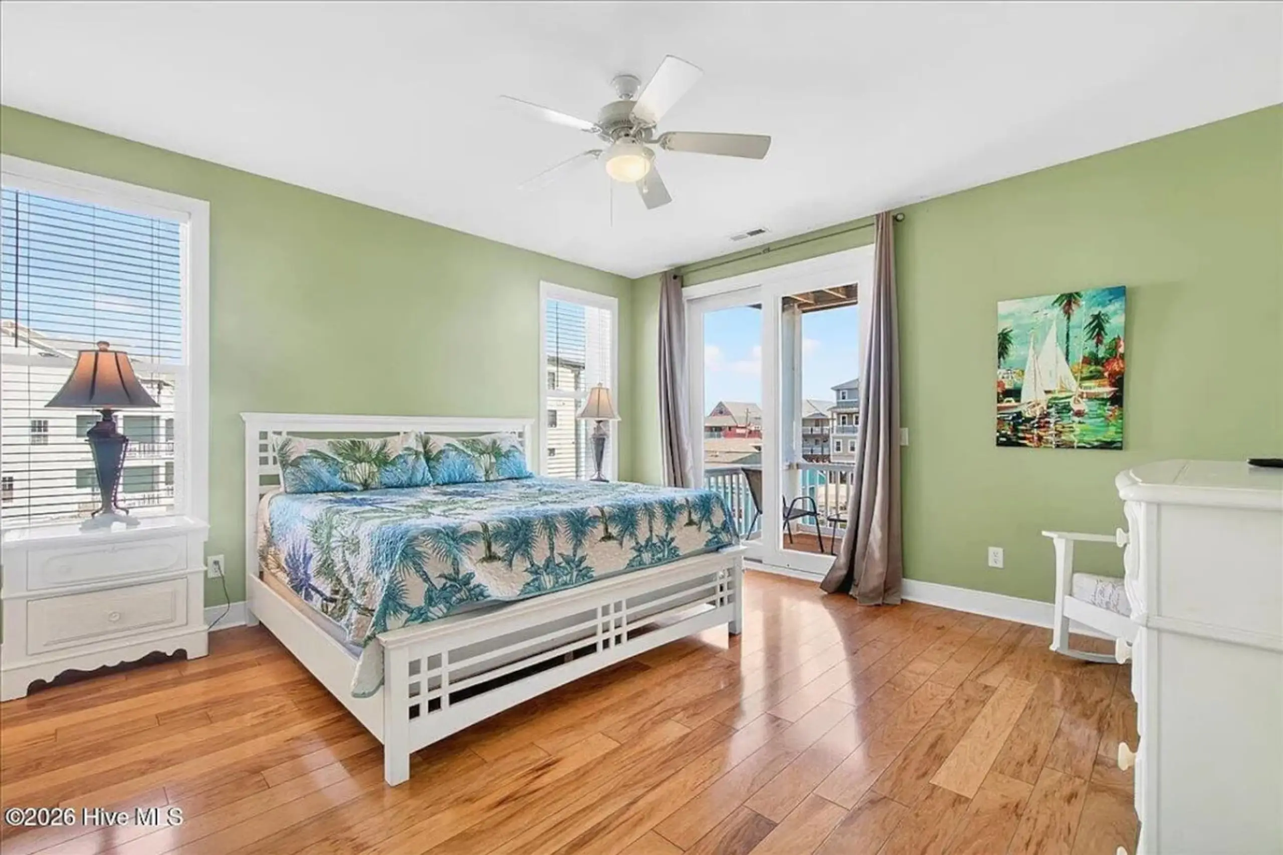 Coastal bedroom with tropical bedding and balcony
