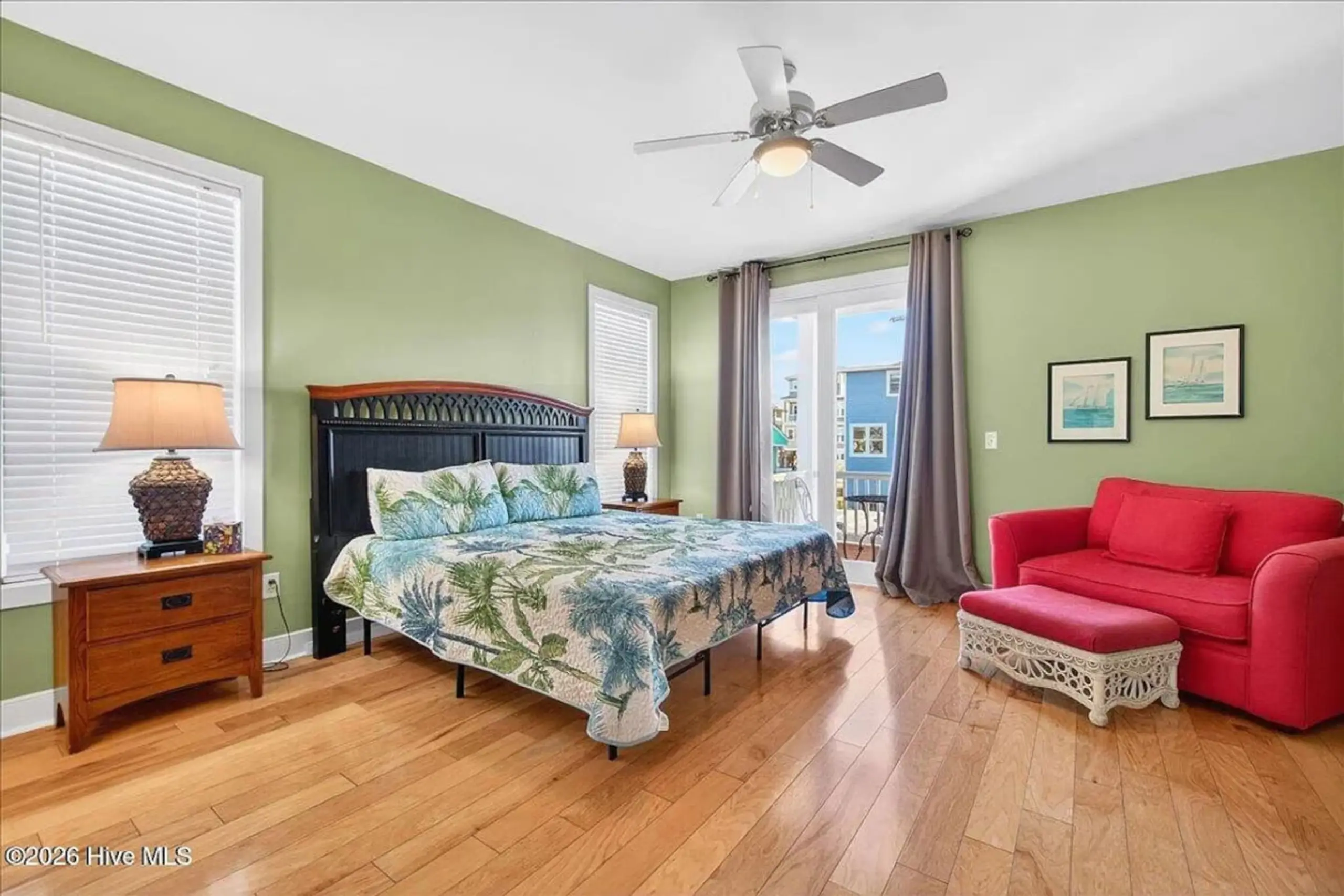 Tropical bedroom with red loveseat and balcony